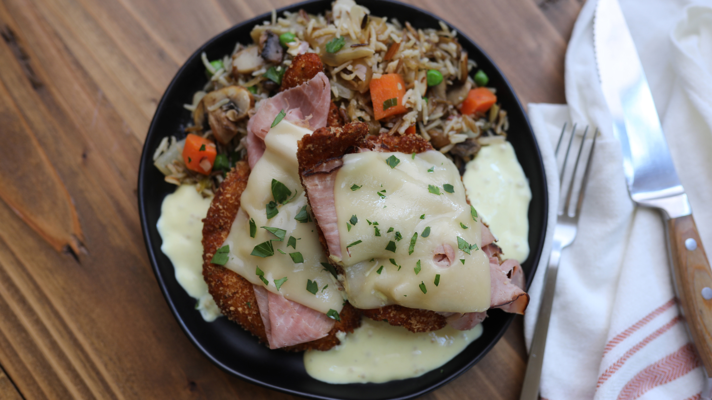 chicken cordon bleu on a black plate