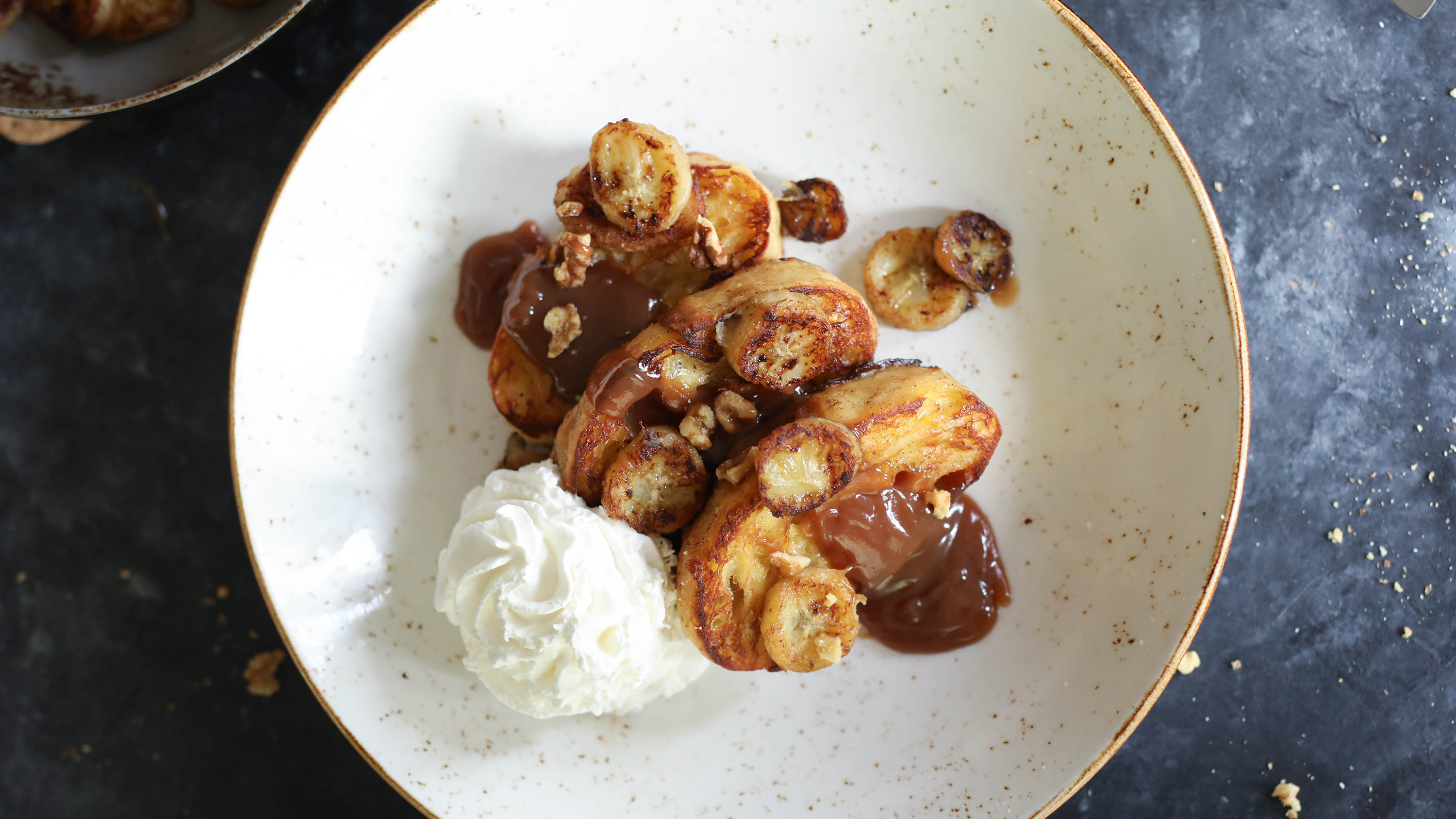 bananas foster french toast on a dark table