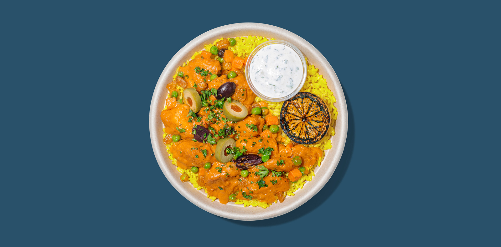 New Roadtrip Bowl called Curry Chicken served with Crispy chicken, spicy harissa curry, peas, carrots, raisins + olives, yellow rice, cooling cucumber sauce  alt tag
