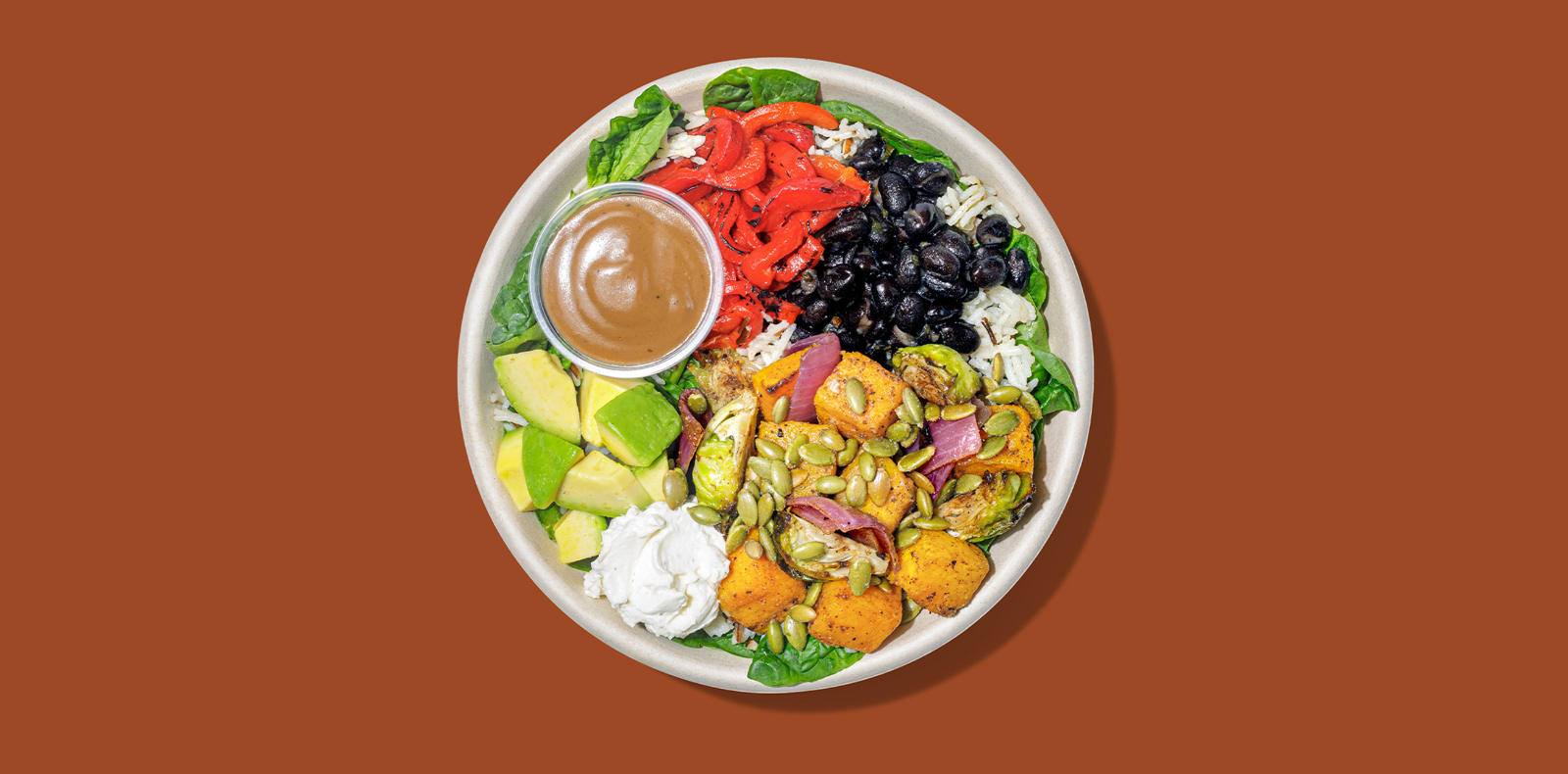 New Roadtrip Bowl called Roasted Veggies + Butternut Squash with Roasted butternut squash, red onion, red bell peppers + brussels sprouts, red lake nation wild rice, baby spinach, goat cheese, black beans, toasted pumpkin seeds, balsamic vinaigrette alt tag