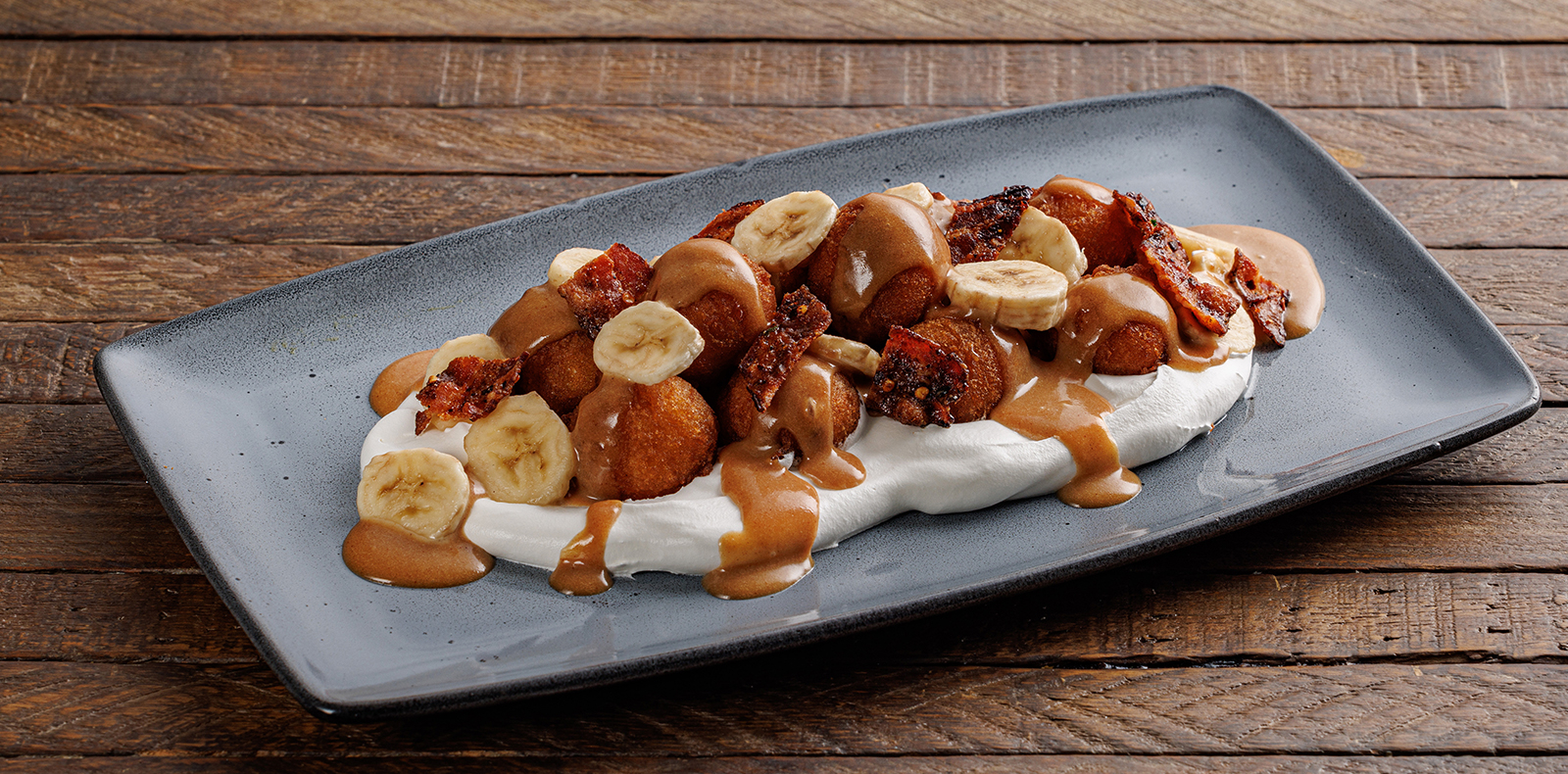Made to order and drizzled with peanut butter caramel, bacon candy, sliced bananas + whipped cream. Available on Lazy Dog’s brunch menu. Kid’s Chocolate Chip Pancakes: Chocolate chip pancakes with maple syrup and whipped cream