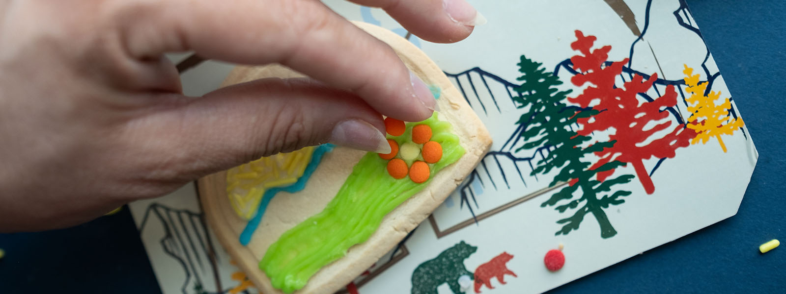 Hand placing candy on a cookie